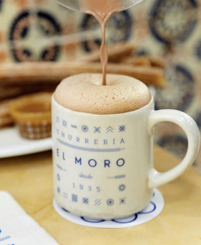 taza de chocolate caliente espumoso con churros 